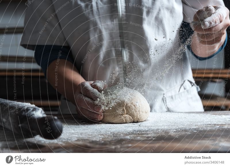 Crop baker kneading dough on table flour bakery cook kitchen ingredient food prepare bread work job chef tradition pastry raw cuisine recipe soft occupation