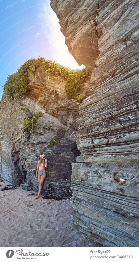 Young woman contemplating a cave made of rocks in Galicia, Spain tourism hiking galicia spain ribadeo castros illas atlantic bay touristic cathedrals cliff