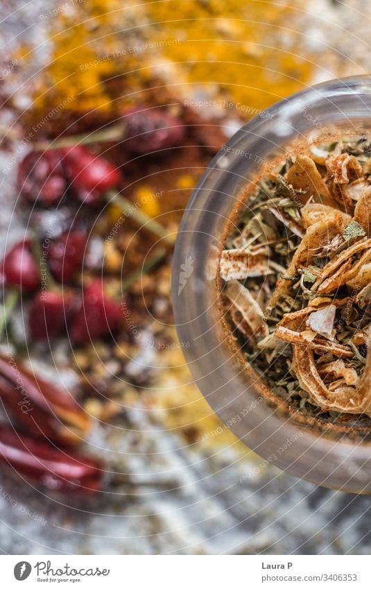 Close up of beautifully arranged colorful condiments in half of a round glass condiments' jar close up colored colors yellow chilli turmeric garlic thyme salt