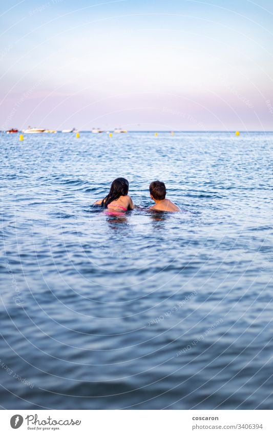 Two little kids swimming on the sea active activity beach beautiful blue carefree child childhood concept copy space cute enjoyment family freedom fun girl