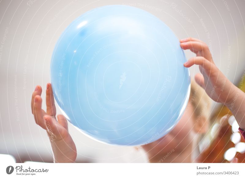 Close up of a child blowing a balloon Child Blow Balloon Playing Girl Portrait photograph Leisure and hobbies Birthday Event Party inflating blue play fun happy