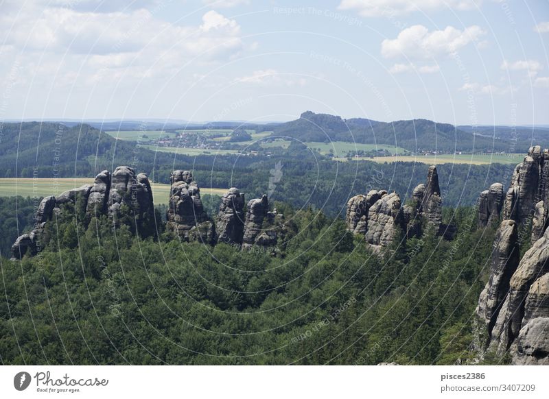 View over the Schrammsteine area and the landscape of Saxon Switzerland climbing clouds journey rocky sandstone switzerland woods blue blue sky cliff