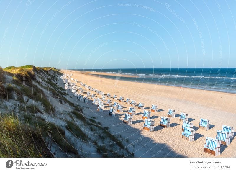 Beach landscape at the North Sea. Famous resort in the Wadden Sea Germany Schleswig-Holstein Wadden sea aligned beach blue chairs coast coastline dunes empty