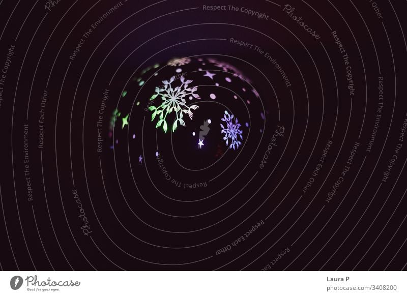 Globe with colored lights on a black background globe colors colorful shaped shapes snowflake snowflakes magic dark lamp circle moon mistery misterious