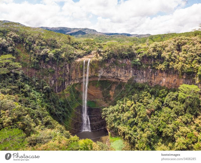 Aerial top view perspective of Chamarel Waterfall in the tropical island jungle of Mauritius. chamarel waterfall mauritius africa flowing forest green landscape