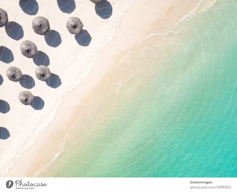 Aerial view of amazing tropical white sandy beach with palm leaves umbrellas and turquoise sea. vacation summer island shore travel landscape background coast