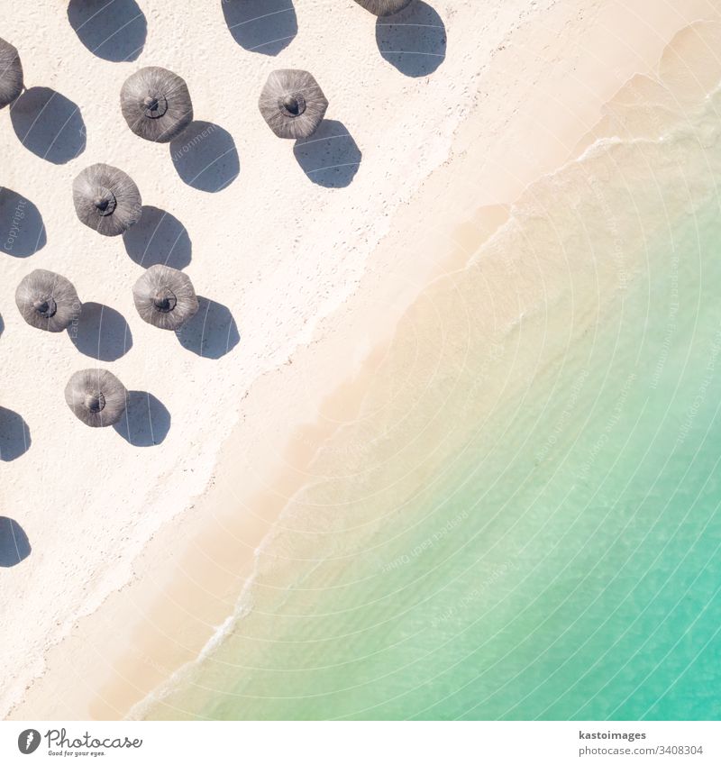 Aerial view of amazing tropical white sandy beach with palm leaves umbrellas and turquoise sea. vacation summer island shore travel landscape background coast