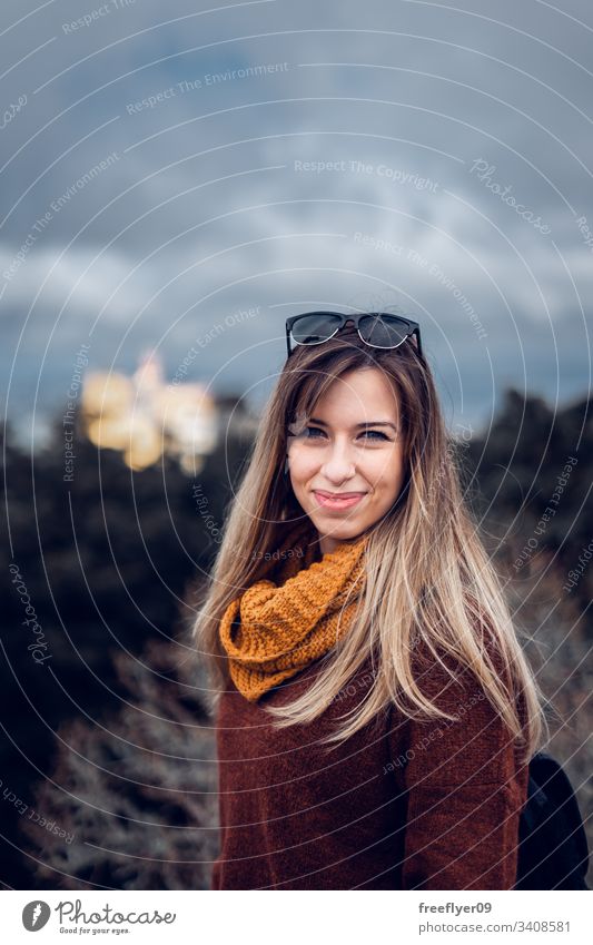 Portrait of a young woman hiking over a forest portrait vertical blonde sunglasses scarf jersey backpack exterior tourist copy space 20s healthy female pretty