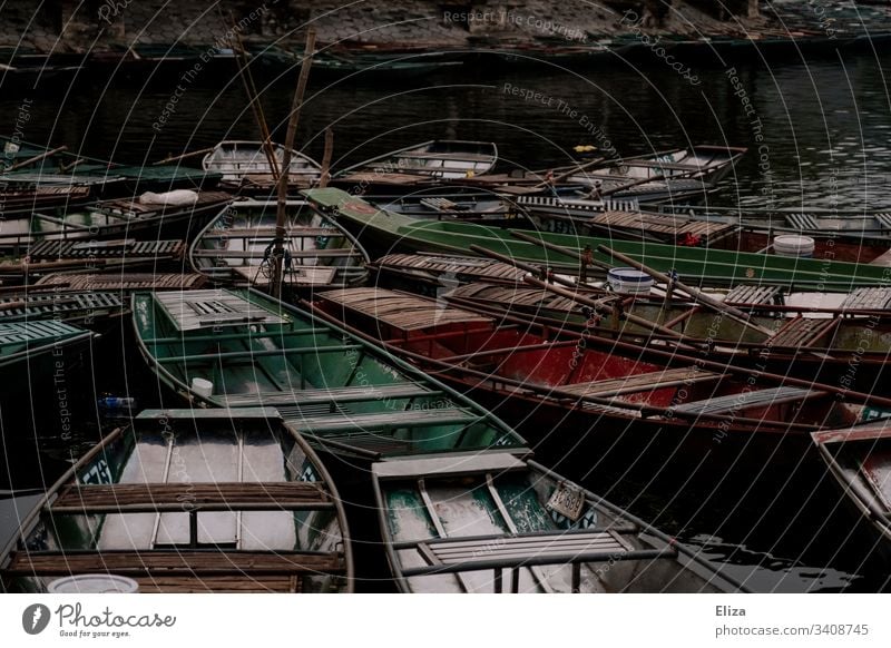 Many colourful little empty rowboats close together made of wood on the water Rowboat Wood variegated Oar Asia Exterior shot Water Colour photo Lake Trip