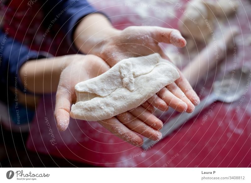 Close up of child hands next to a rolling pin, playing with dough desert Preparation Raw Kitchen Close-up adorable cute sweet close up little baking cooking