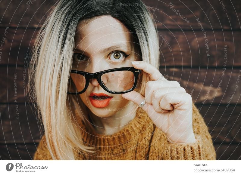 Close portrait of a beautiful nerdy woman glasses eyewear fashion trendy model blonde rimmed glasses ombre hairstyle cool attractive pretty face accessories