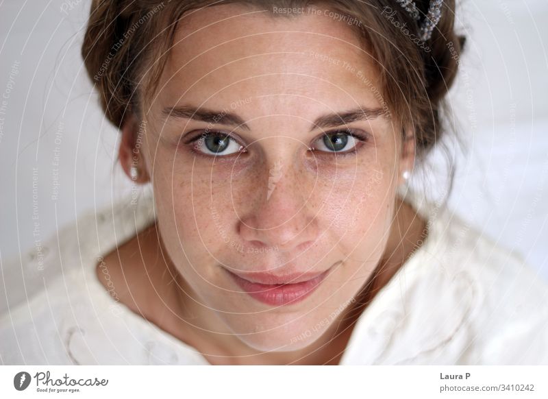 Young smiling woman with braided hair, dressed in white young face natural look close up portrait green eyes peaceful nice beautiful beauty fresh silent