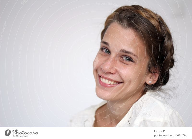 Young smiling woman with braided hair, dressed in white young face natural look close up portrait green eyes peaceful nice beautiful beauty fresh silent