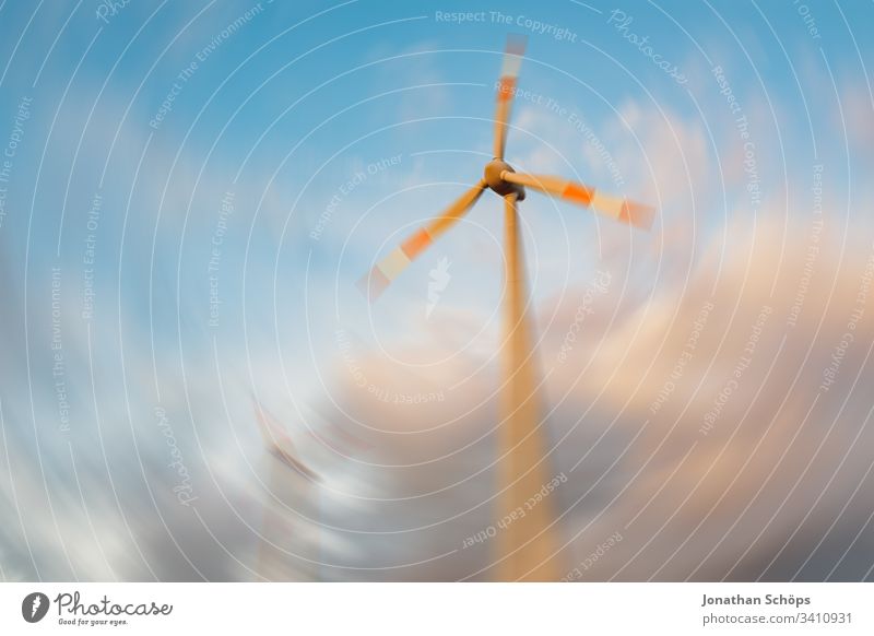 ecological renewable green energy wind power station on a field in evening sun alternative background blue blur change clean climate change cloud clouds