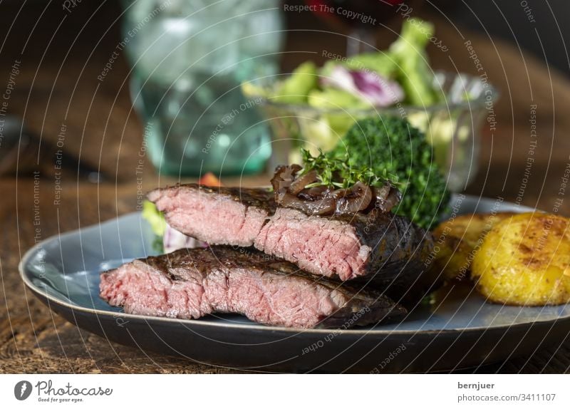 Halves of a steak on the plate beef steak Steak sirloin Argentinean main course caramelized Onion Close-up bovine hip Juicy Delicious Meat Eating Dinner Frying