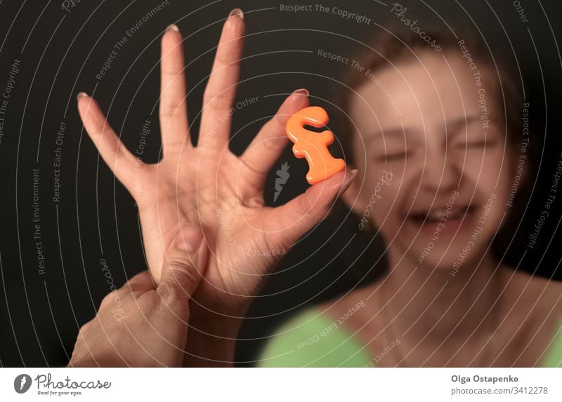 Girl holds letter F. in her hand.  Alphabet/ Family concept. family concept joy friendship mutual assistance girl smile close-up face love happiness school