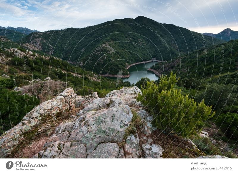 View of lake and green mountains with rocks in the foreground Vantage point Green Forest Bushes Sky Clouds Mountain Hill Landscape Nature Tree Grass Meadow