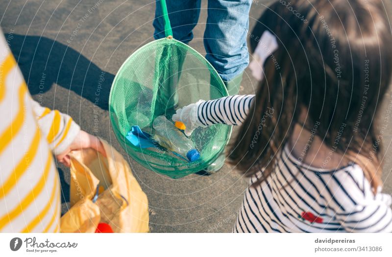 Volunteers taking garbage out of the sea top view fishing net plastic shore grandfather grandchildren showing environment garbage bags unrecognizable bottle