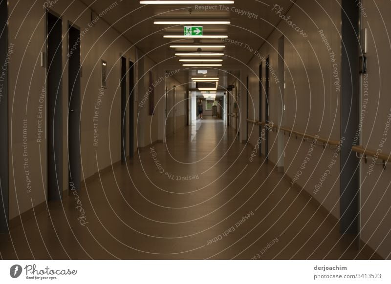 Light at the end of the corridor , with indication sign - to the emergency exit in a clinic. Hallway Architecture Building Deserted Colour photo Day