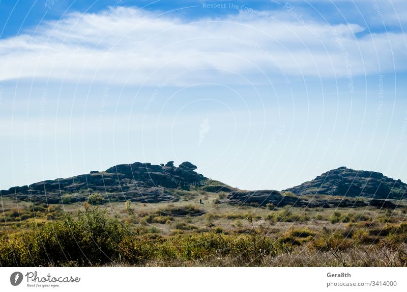 stone mountains and
blue sky with white clouds bushes clear day field grass gray landscape mountain landscape nature plants rocks stones summer sunny travel