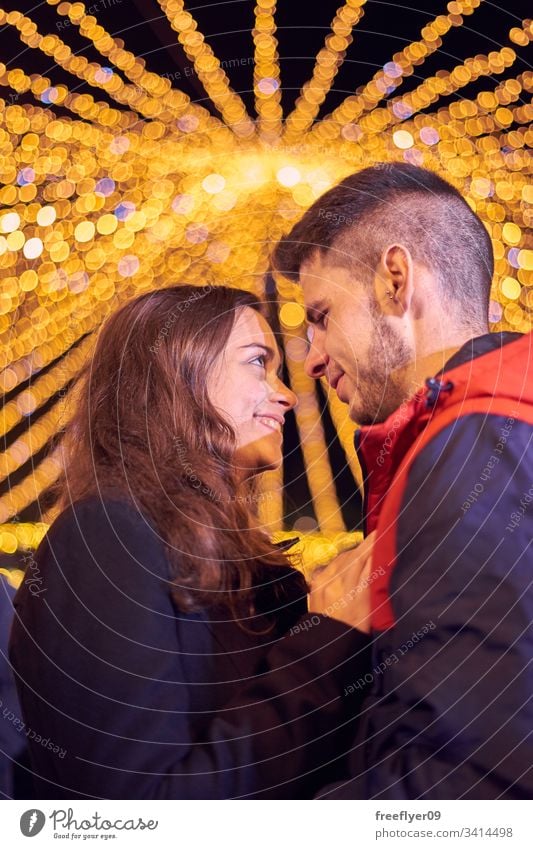 Young couple enjoying Christmas Lights Vigo Galicia Spain Tourism love kiss young caucasian pair two tourists christmas lights lighting bokeh smiling night hug