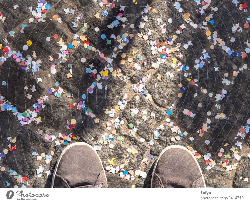 Pavement covered with colorful confetti and shoes carnival celebrate road street texture abstract holiday pavement street photography urban celebration detail