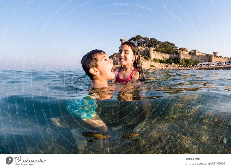 Two little kids playing into the sea active beach beautiful blue boy boys child childhood children cute emotional enjoy excited face family fresh fun happiness