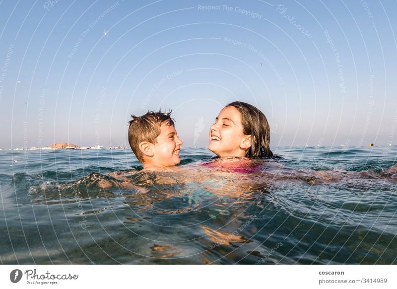 Two little kids playing into the sea active beach beautiful blue boy boys child childhood children cute emotional enjoy excited face family fresh fun happiness