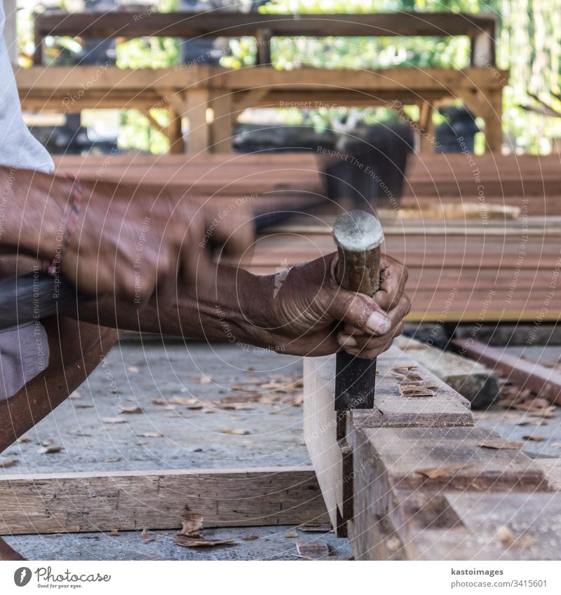 Close up of warn hands of carpenter working in traditional manual carpentry shop in a third world country. wood workshop timber equipment woodwork construction