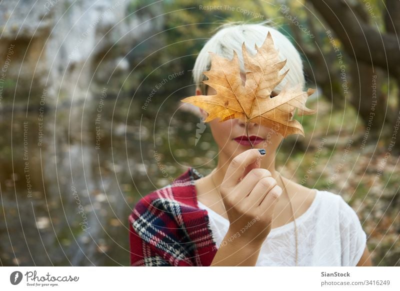 Blonde woman holding a leave. glowing person flame party forest winter woods lake sparkle sparkler year young holiday beautiful eve fire bengal hand xmas new