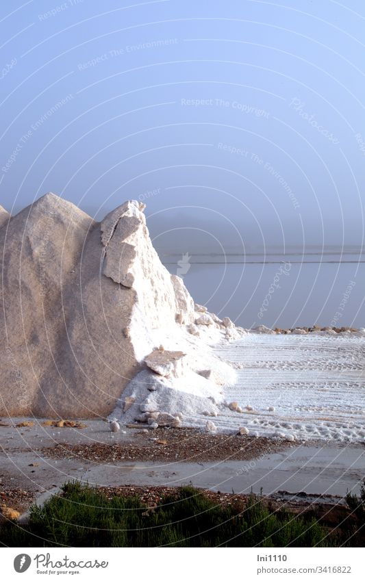 cleared salt mountain with a view of the white salt in the background the salt works in the bluish morning mist salt extraction Saltworks Mediterranean sea