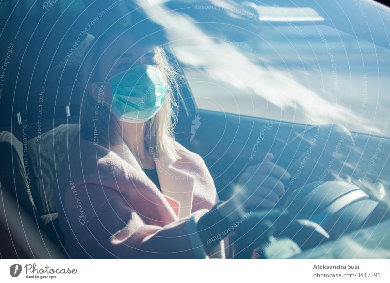 Woman in protective mask driving a car on road. Safe traveling. automobile breathing city coronavirus covid-19 dashboard destination drive driver driveway