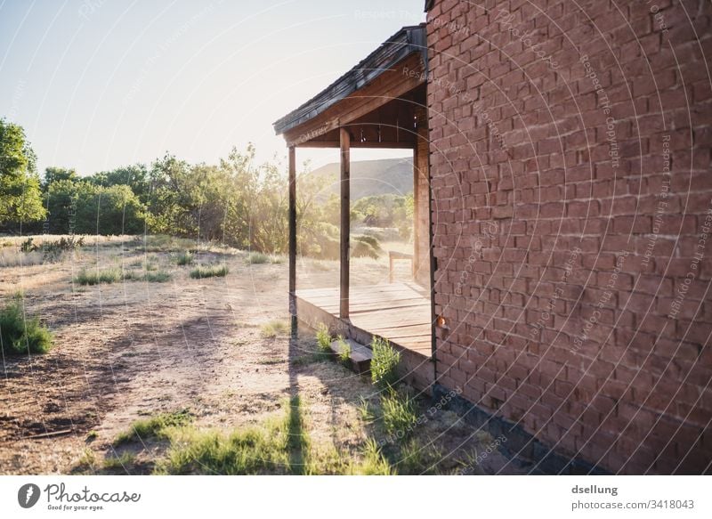 Brick house with wooden canopy in back light Historic Old town Facade Manmade structures Building tranquillity Lonely forsake sb./sth. Architecture Adventure