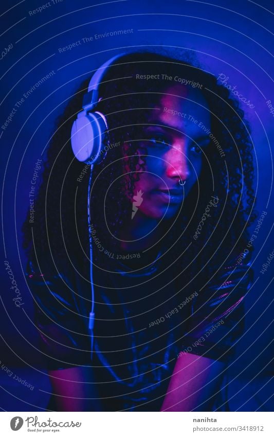 Artistic portrait with color lights of a young woman neon black art artistic cool afro afro american music headphones headset technology listening dj african