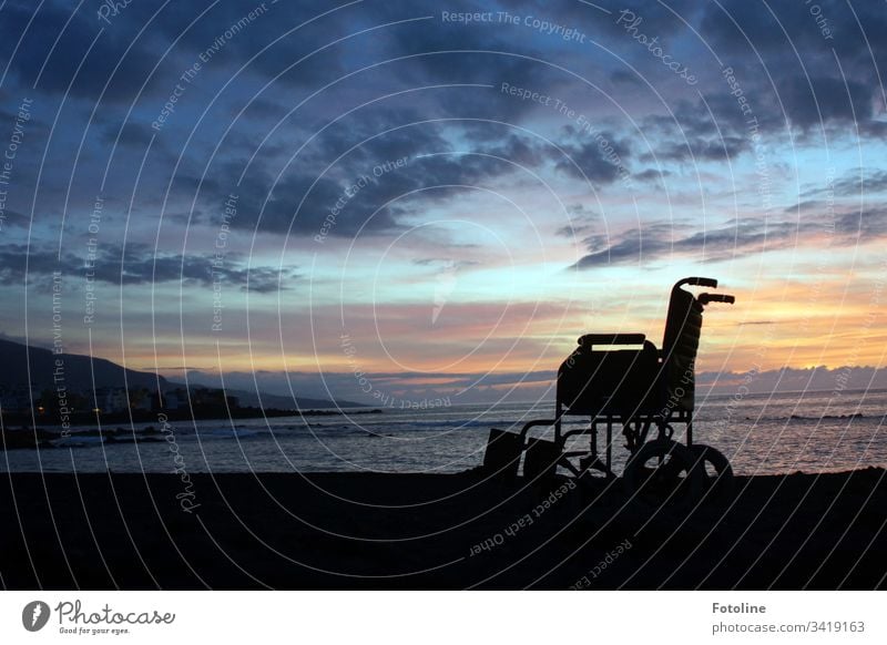 Wheelchair on the beach of Puerto de la Cruz in Tenerife at sunset Mountain Landscape Exterior shot Sky Nature Colour photo Deserted Clouds Sunset