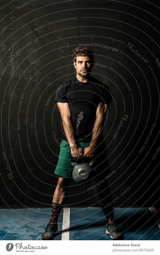 Muscular sportsman with kettlebell in gym weightlifting functional training muscular fitness healthy male athlete exercise power strong body sportswear physical