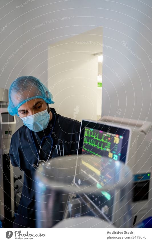 Pensive adult in protective mask and uniform in clinic doctor hospital medicine man medical surgery check professional male assistant tool specialist care