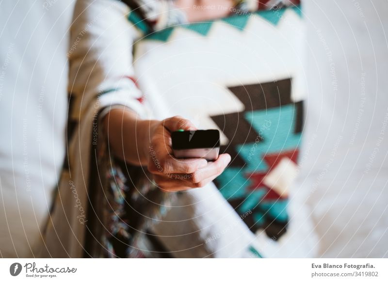 close up view of unrecognizable woman holding remote tv control at home. Television and technology concept television young indoors daytime modern alone quest