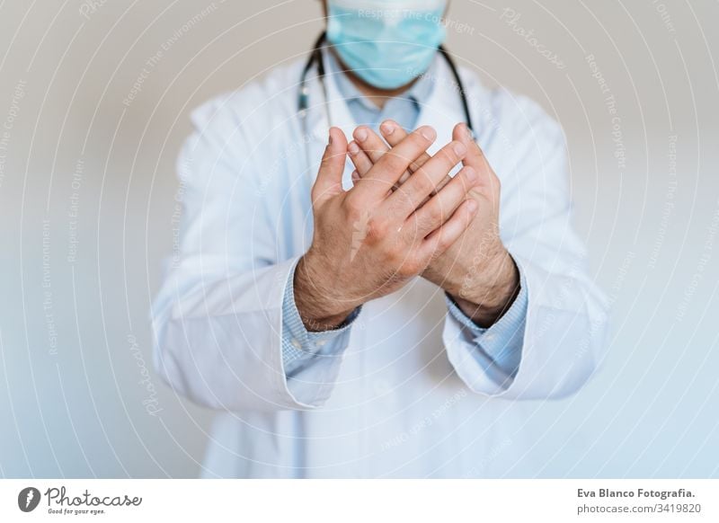 caucasian doctor wearing protective mask and gloves indoors. Using an alcohol gel or antibacterial disinfectant. Hygiene and corona virus concept man