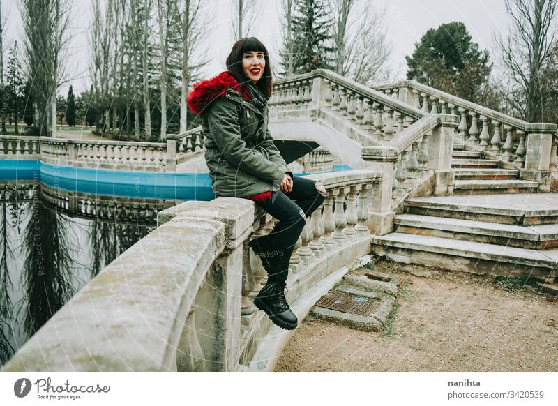 Young cool woman with ghotic style in an urban place city winter clothes goth rock modern casual wear trendy coolness fresh freshness youth outdoors park