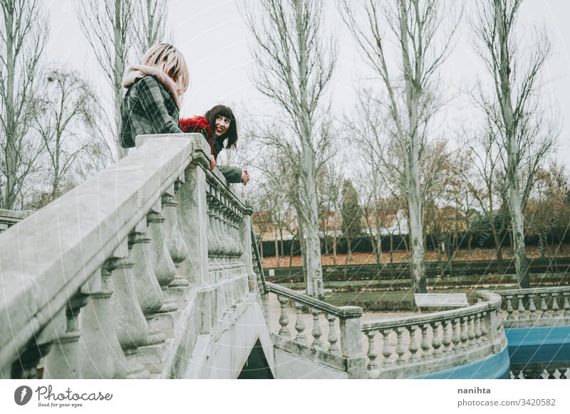 Two young and casual women spending time together friends trendy youth friendship two urban outdoors funny enjoy life lifestyle youthful fresh real candid