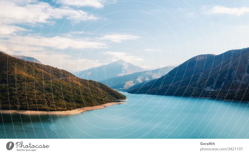 autumn landscape of mountains and lake in Georgia Caucasus background blue bright calm climate autumn clouds color day fog forest green haze hill holiday