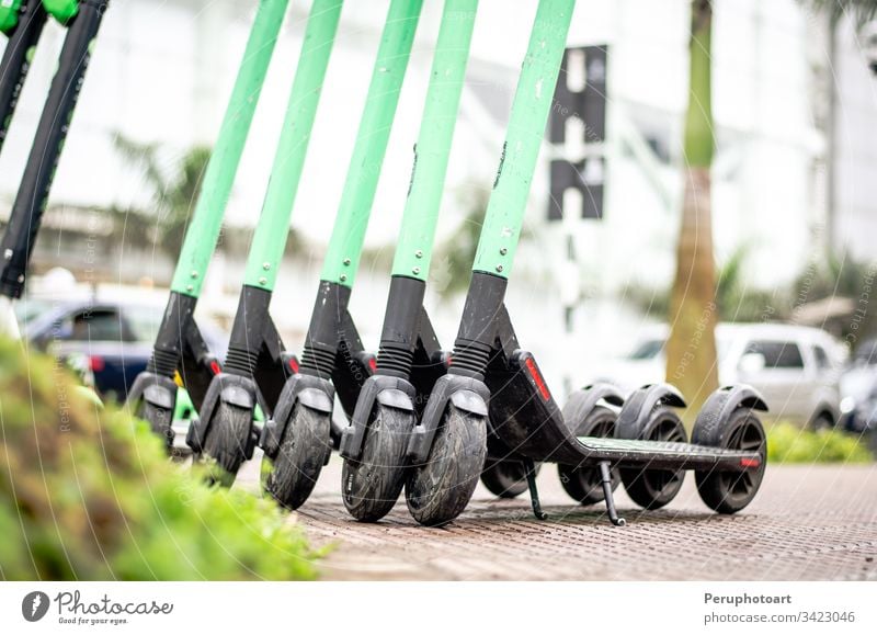 Modern eco electric city scooters for rent outdoors on the sidewalk. Alternative tourism, transportation around the city, bike replacement service. e-scooter