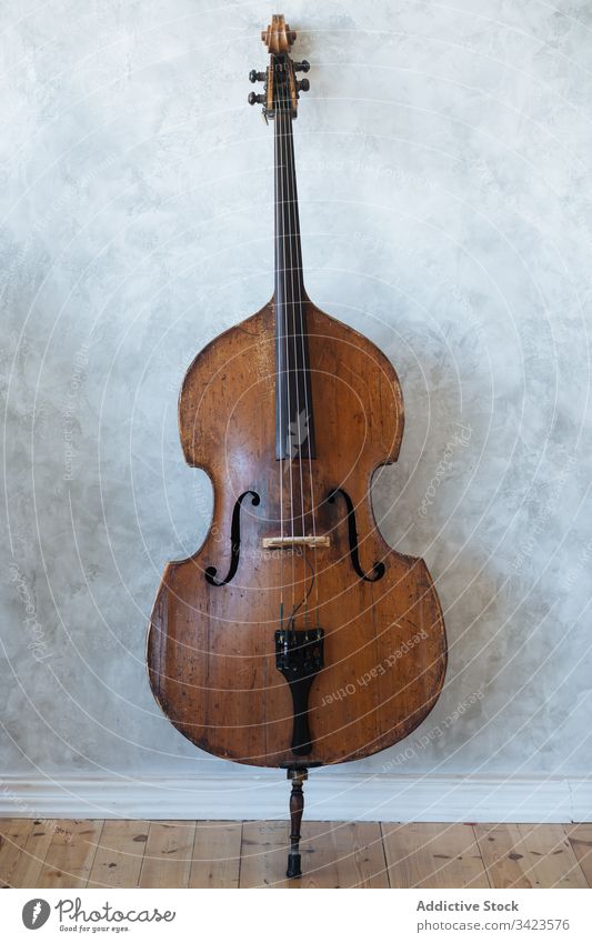 Brown wooden violin against wall music musician instrument grey classic string hobby equipment modern detail skill harmony tune culture entertain style home