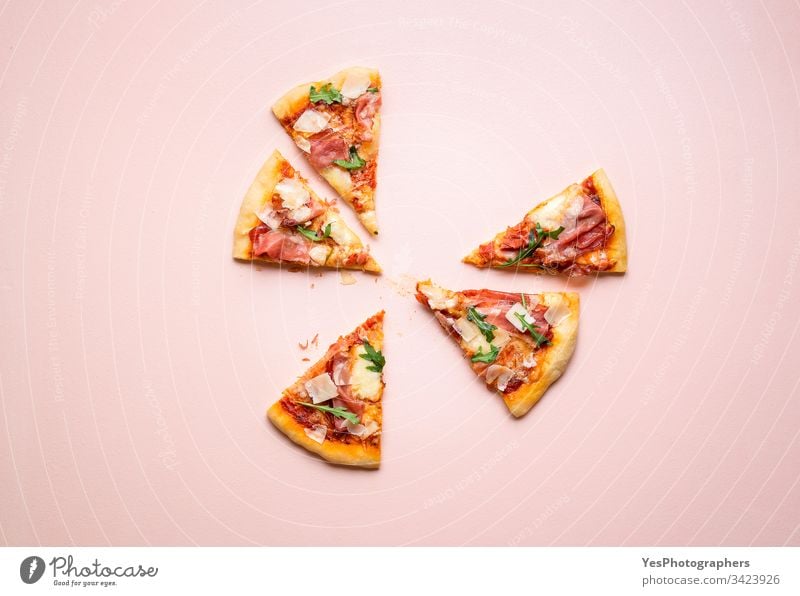 Pizza prosciutto slices on pink background. Italian  popular food arugula carbs cheese and ham cuisine dinner eating european famous fast food finger food