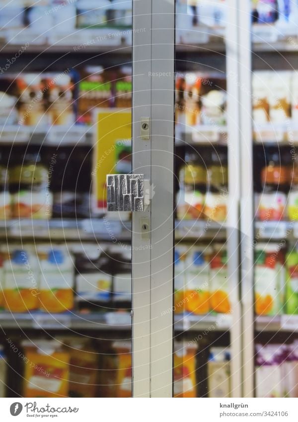 View through the closed entrance door of a supermarket to full food shelves Food grocery store Supermarket discount Front door Closed Colour photo Door Entrance