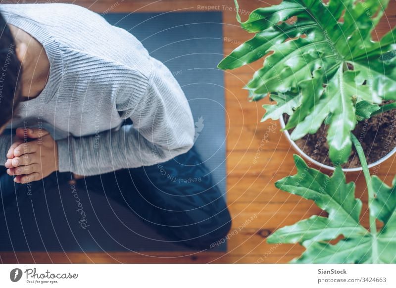 Woman doing yoga in the morning at her home, top view. mat woman fitness young health exercise workout wellness lotus asana pose pray maditation gym female girl