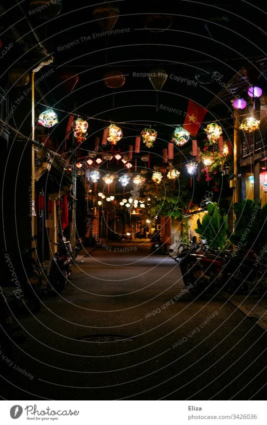 An alley at night with many colorful glowing lanterns in Hoi An, Vietnam lampions Illuminate variegated Decoration Alley Street clearer touristic Tourism travel