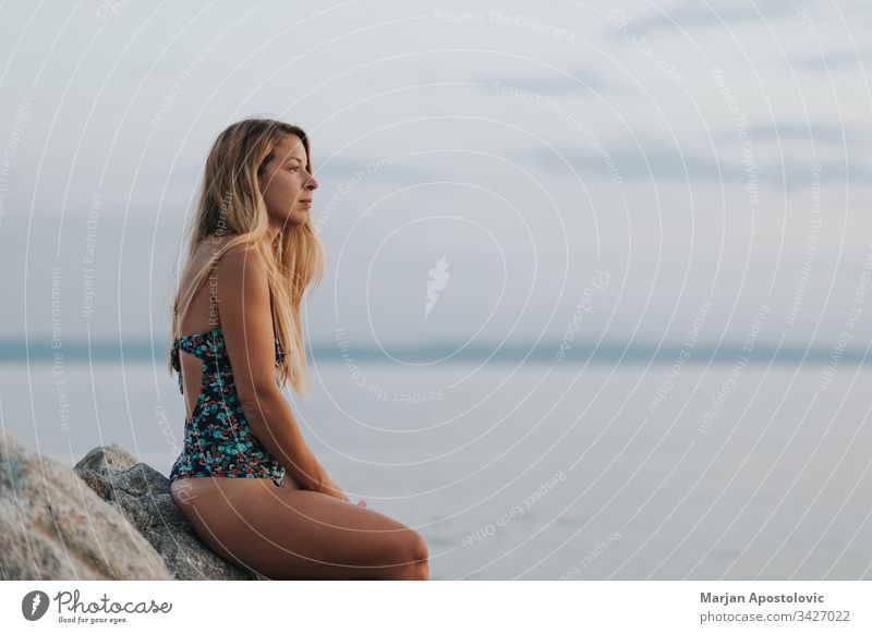 Young woman enjoying sunset on the beach alone beautiful calm coast dawn dreamy dusk enjoyment evening female freedom future girl holiday horizon landscape