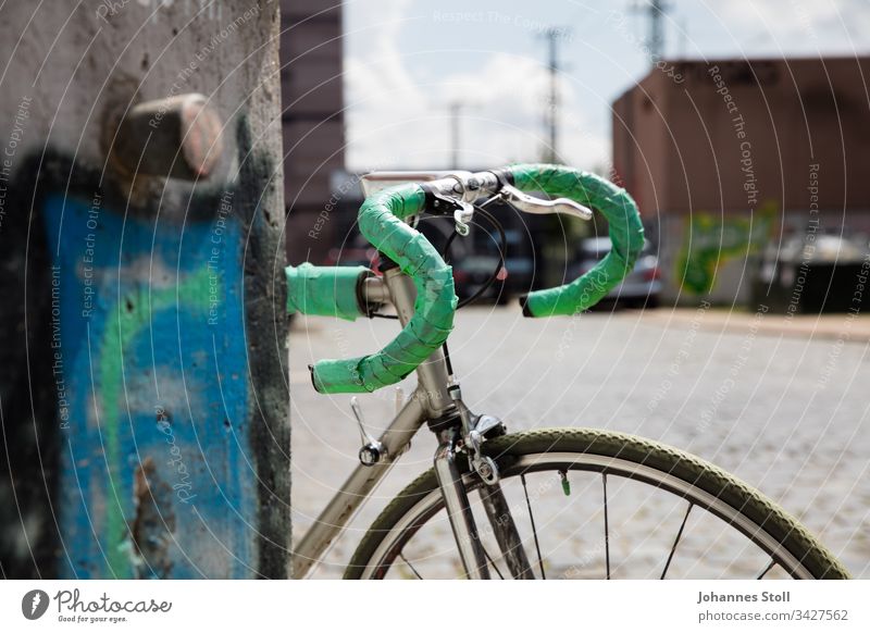 Vintage road bike with green handlebar tape leaning against graffiti wall Racing cycle Retro vintage Steel Aluminium Bicycle Hipster urban Town Transport